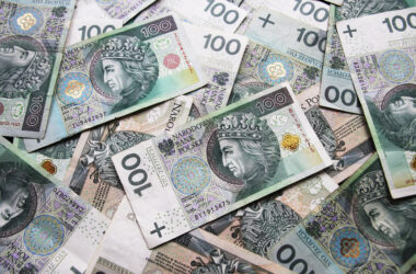 Stos polskich banknotów 100 złotowych rozłożonych na płaskiej powierzchni