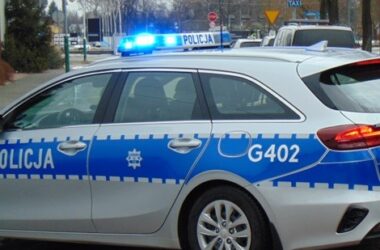 adiowóz Komendy Powiatowej Policji w Oświęcimiu z włączonymi niebieskimi sygnałami świetlnymi