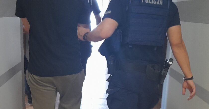 Policjant z Komisariatu Policji w Zatorze prowadzi zatrzymanego 31-letniego mężczyznę, podejrzanego o znęcanie się nad matką i usiłowanie rozboju. Zatrzymanie nastąpiło po domowej awanturze, która ujawniła wieloletnią przemoc psychiczną i fizyczną wobec 54-letniej kobiety.