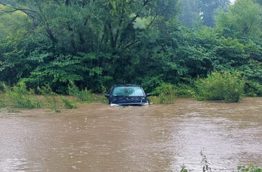 Zanurzony w wodzie samochód marki Opel w rzece Soła w miejscowości Łęki (gmina Kęty), po intensywnych opadach deszczu. W tle zarośla i most.