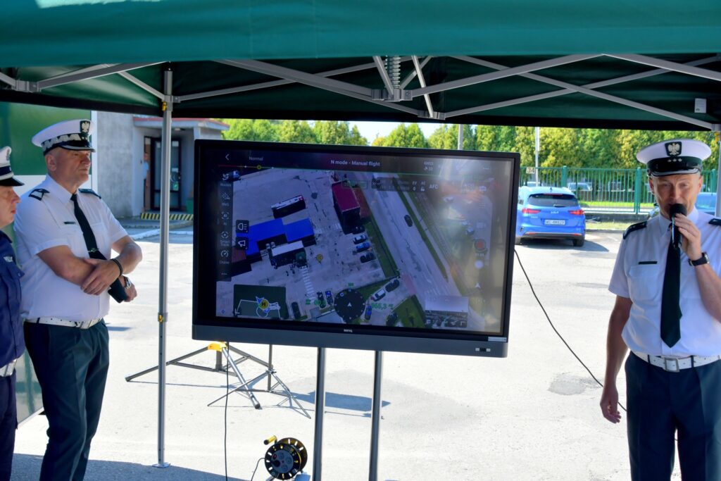 Inspektorzy ITD podczas prezentacji działania drona, na ekranie widok z kamery bezzałogowego statku powietrznego DJI MATRICE 4TD, wykorzystywanego do kontroli drogowej.