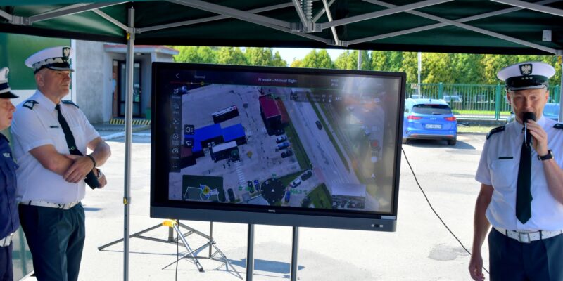 Inspektorzy ITD podczas prezentacji działania drona, na ekranie widok z kamery bezzałogowego statku powietrznego DJI MATRICE 4TD, wykorzystywanego do kontroli drogowej.