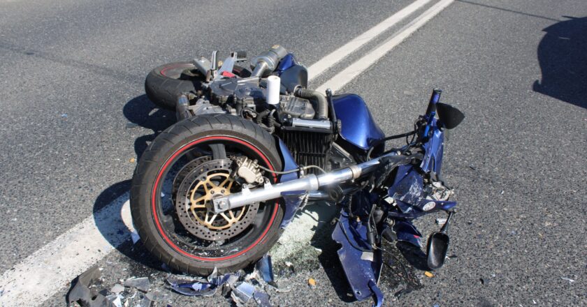 Rozbity motocykl leży na jezdni po wypadku drogowym w Rajsku – widoczne uszkodzenia maszyny i rozrzucone odłamki plastiku.