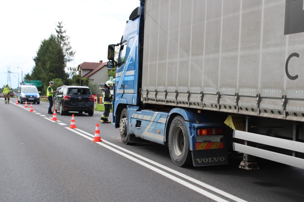 Policjanci i strażacy na miejscu wypadku w Bulowicach na DK52, gdzie samochód ciężarowy marki Volvo najechał na tył osobowego Citroena. Na zdjęciu widać uszkodzone pojazdy oraz działania służb ratunkowych.