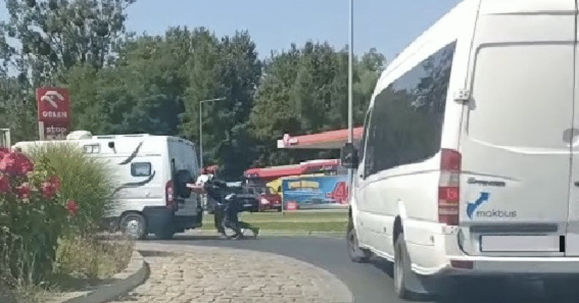 Policjanci z Wydziału Ruchu Drogowego w Oświęcimiu pomagają kierowcy kampera zepchnąć pojazd z ulicy po awarii.