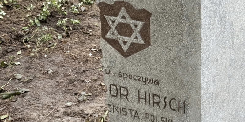 Fragment odrestaurowanego nagrobka Icchaka Izydora Hirscha na cmentarzu żydowskim w Oświęcimiu, z widoczną Gwiazdą Dawida – symbolem żydowskiej tożsamości i napisem upamiętniającym legionistę polskiego.