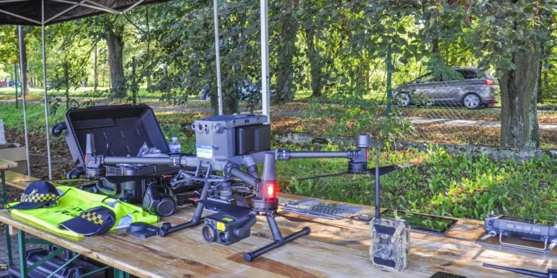 Nowoczesny dron DJI Matrice 350 RTK z kamerą Zenmuse H30T na stole wraz z wyposażeniem Straży Miejskiej w Kętach, używany do kontroli jakości powietrza i walki ze smogiem.