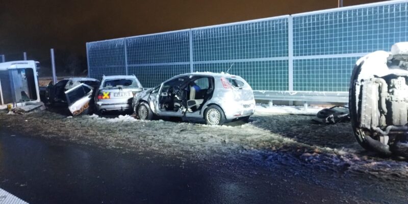 Uszkodzone samochody stojące i przewrócone na oblodzonej jezdni podczas nocnych ćwiczeń służb ratunkowych MAYDAY’25 na obwodnicy Oświęcimia.