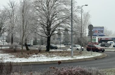 Odsłonięty Skwer Praw Kobiet w Oświęcimiu z czerwoną wstęgą na tabliczce, widok na rondo i zimowy krajobraz