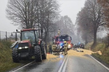 Strażacy i policjanci zabezpieczają miejsce zdarzenia na DK44 w Przeciszowie, gdzie z przyczepy traktora wysypała się kukurydza, blokując oba pasy ruchu.