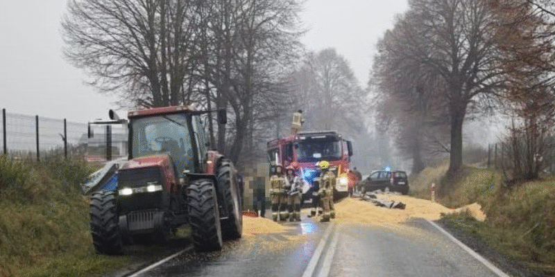 Strażacy i policjanci zabezpieczają miejsce zdarzenia na DK44 w Przeciszowie, gdzie z przyczepy traktora wysypała się kukurydza, blokując oba pasy ruchu.
