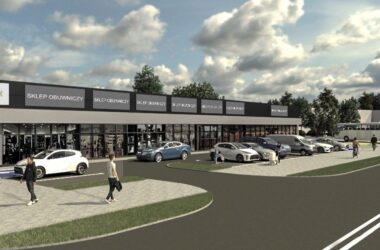 Wizualizacja parku handlowego Higasa Park Oświęcim – nowoczesny, jednokondygnacyjny budynek usługowo-handlowy z dużymi przeszklonymi witrynami, przed którym znajduje się parking z zaparkowanymi samochodami i pieszymi. Obiekt zlokalizowany u zbiegu ulic Legionów i Garbarskiej.