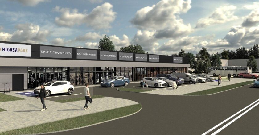 Wizualizacja parku handlowego Higasa Park Oświęcim – nowoczesny, jednokondygnacyjny budynek usługowo-handlowy z dużymi przeszklonymi witrynami, przed którym znajduje się parking z zaparkowanymi samochodami i pieszymi. Obiekt zlokalizowany u zbiegu ulic Legionów i Garbarskiej.