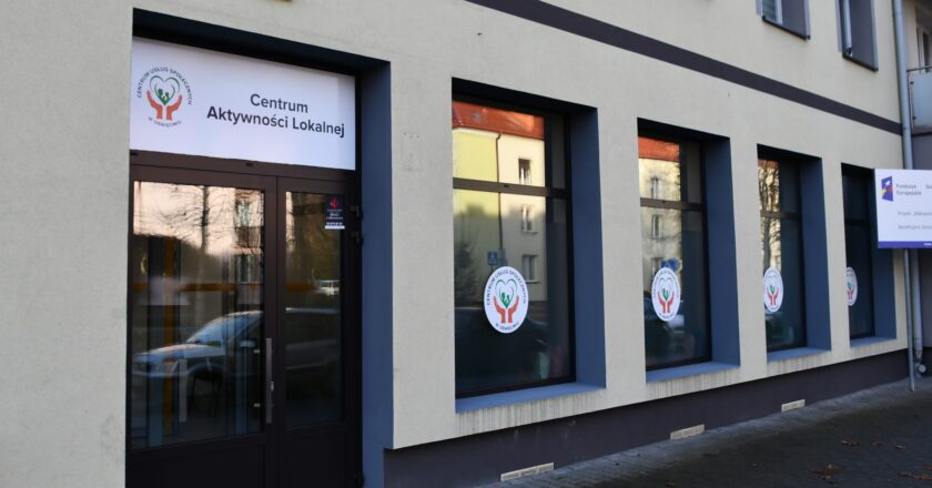 Wejście do Centrum Aktywności Lokalnej w Oświęcimiu – elewacja budynku z przeszklonymi drzwiami i oknami oznaczonymi logo Centrum Usług Społecznych.