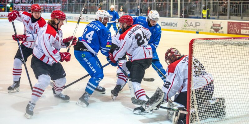 Zawodnicy Cracovii i Unii Oświęcim walczą o krążek przed bramką gospodarzy podczas meczu hokejowego; bramkarz interweniuje w chaosie podbramkowym. Foto: Jarosław Fiedor / Unia Oświęcim.