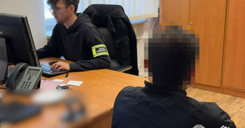 Kontrola legalności pobytu cudzoziemca prowadzona przez funkcjonariusza Straży Granicznej w pomieszczeniu służbowym, wizerunek osoby kontrolowanej zamazany