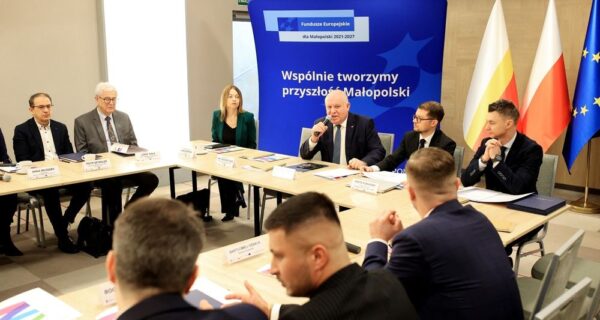 Pierwsze posiedzenie Rady Programowej ds. Sprawiedliwej Transformacji Małopolski Zachodniej w Radoczy – wicemarszałek Ryszard Pagacz przemawia do uczestników obrad, przy stole przedstawiciele samorządów, nauki i partnerów społecznych, w tle baner Funduszy Europejskich i flagi Polski oraz UE.