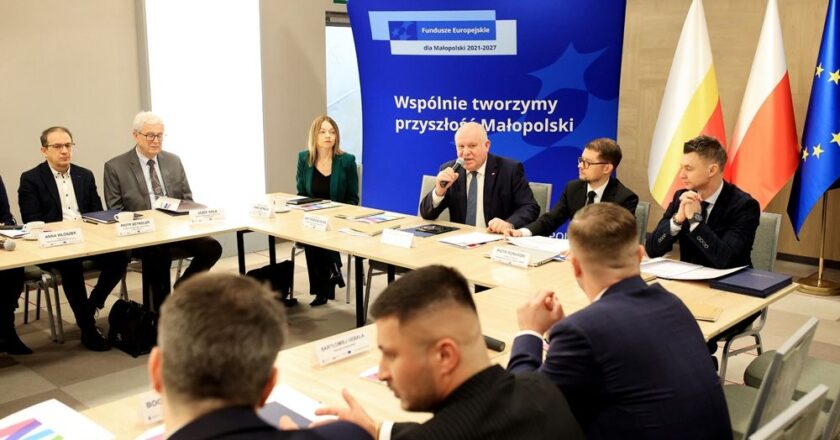 Pierwsze posiedzenie Rady Programowej ds. Sprawiedliwej Transformacji Małopolski Zachodniej w Radoczy – wicemarszałek Ryszard Pagacz przemawia do uczestników obrad, przy stole przedstawiciele samorządów, nauki i partnerów społecznych, w tle baner Funduszy Europejskich i flagi Polski oraz UE.