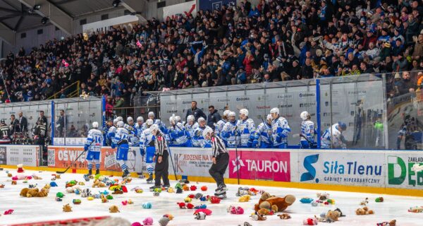 Kibice Unii Oświęcim wypełniający trybuny lodowiska podczas meczu, a na tafli dziesiątki pluszowych misiów rzuconych w ramach akcji Teddy Bear Toss.