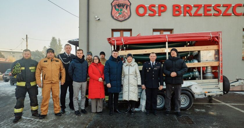 Przekazanie nowego sprzętu dla OSP Brzeszcze – strażacy ochotnicy i przedstawiciele samorządu przed remizą z agregatem pompowym i wyposażeniem ratowniczym