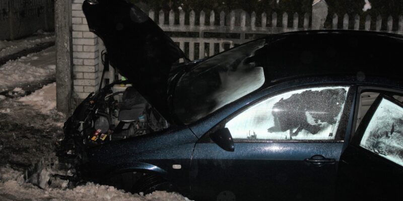 Uszkodzony samochód osobowy po wypadku drogowym w Osieku – auto w rowie przy posesji, nocne warunki, widoczne zniszczenia przodu pojazdu i otwarta maska.