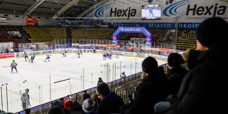 Międzynarodowy turniej hokejowy w hali lodowej w Oświęcimiu – mecz akademickich drużyn, zawodnicy na lodzie i kibice na trybunach podczas rywalizacji ACHA i UHT Sabers