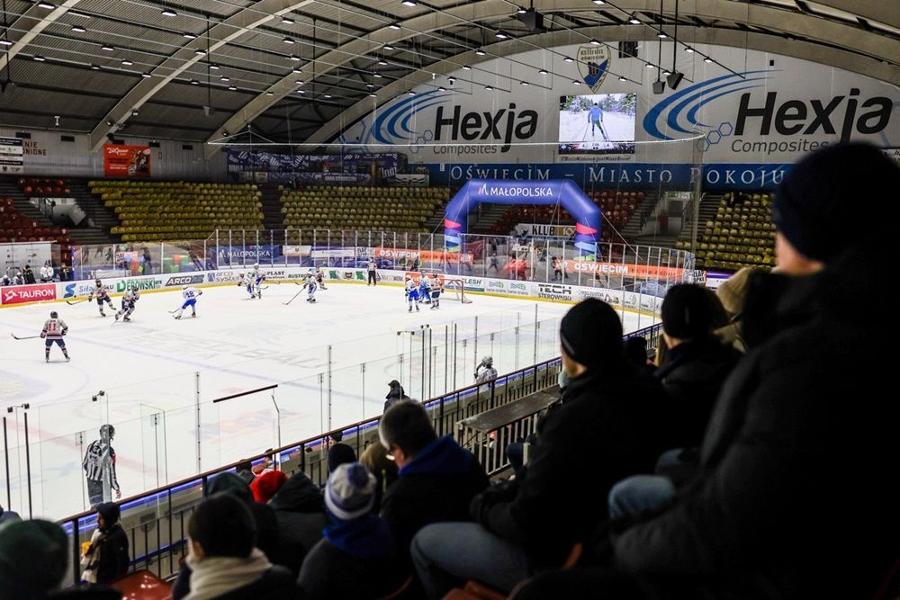 Międzynarodowy turniej hokejowy w hali lodowej w Oświęcimiu – mecz akademickich drużyn, zawodnicy na lodzie i kibice na trybunach podczas rywalizacji ACHA i UHT Sabers