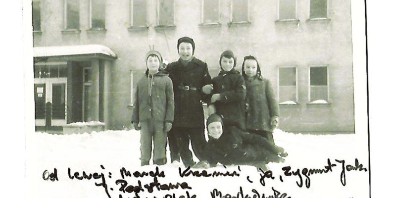 Archiwalne czarno-białe zdjęcie z zimy 1962/1963 roku – grupa chłopców z Oświęcimia przed przedszkolem przy ul. Bronisława Czecha, podpisane odręcznie nazwiskami kolegów z podwórka