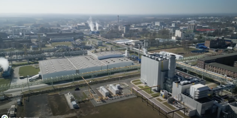 Widok z lotu ptaka na kompleks przemysłowo-energetyczny Synthos w Oświęcimiu – elektrociepłownia z nowoczesną instalacją gazową CCGT, budynki techniczne, rurociągi i infrastruktura energetyczna na tle miasta i terenów przemysłowych.