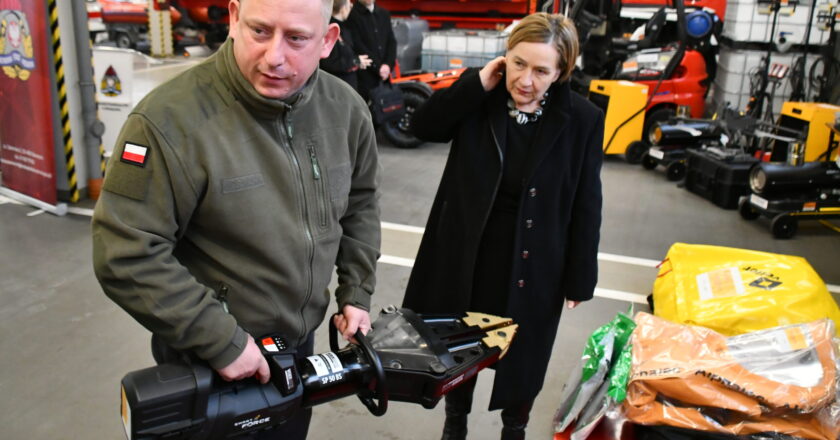 Prezentacja nowoczesnego sprzętu ratowniczego w Komendzie Powiatowej PSP w Oświęcimiu – strażak demonstruje hydrauliczne narzędzie ratownicze, obok przedstawicielka władz oglądająca wyposażenie zakupione w ramach Programu Ochrony Ludności i Obrony Cywilnej.