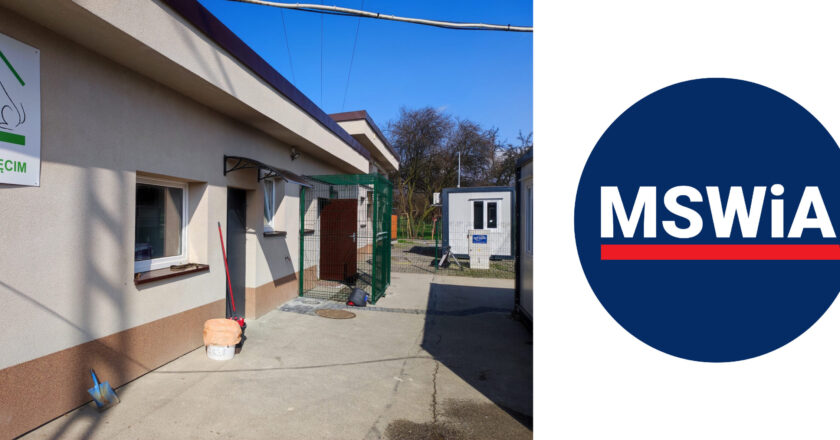 Wejście na teren schroniska dla zwierząt w Oświęcimiu – widok na budynek administracyjny, ogrodzoną bramę i zaplecze techniczne; po prawej stronie graficzne logo Ministerstwa Spraw Wewnętrznych i Administracji (MSWiA).
