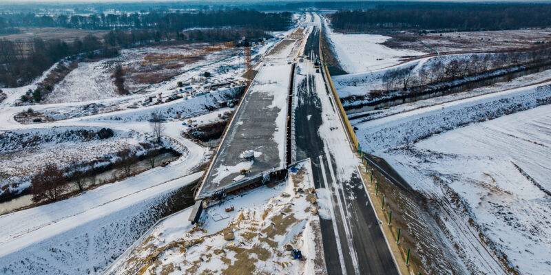 Budowa trasy S1 w rejonie węzła Bieruń zimą – widok z lotu ptaka na most nad Gostynią i nowy odcinek drogi w trakcie realizacji