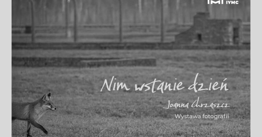 Plakat czarno-białej wystawy fotografii „Nim wstanie dzień” Joanny Chrząszcz, lis na tle terenu byłego obozu Auschwitz-Birkenau, MDSM Oświęcim