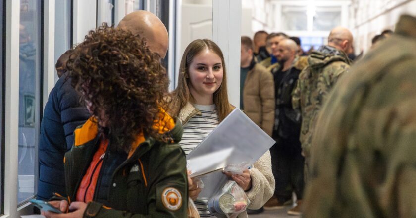 Ochotnicy zgłaszający się na szkolenie „Ferie z WOT” w 11 Małopolskiej Brygadzie Obrony Terytorialnej – młoda kandydatka z dokumentami w ręku w kolejce rekrutacyjnej w budynku jednostki wojskowej.