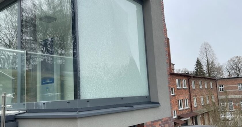 Uszkodzona szklana szyba w części socjalnej parkingu przy ul. Bulwary w Oświęcimiu – skutek aktu wandalizmu
